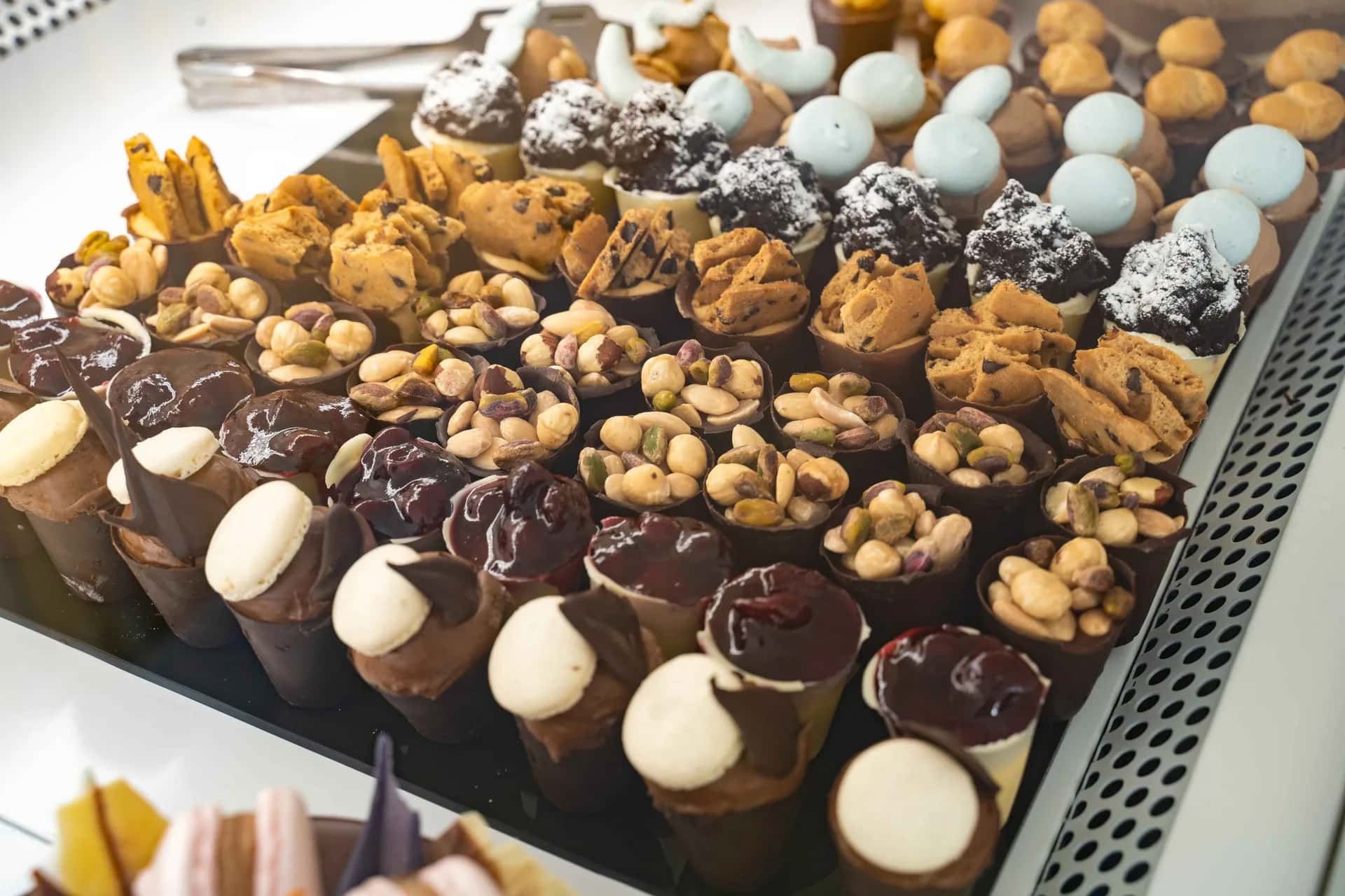 Dessert table spread with assorted mini pastries, cones and sweet bites by Epoca Patisserie