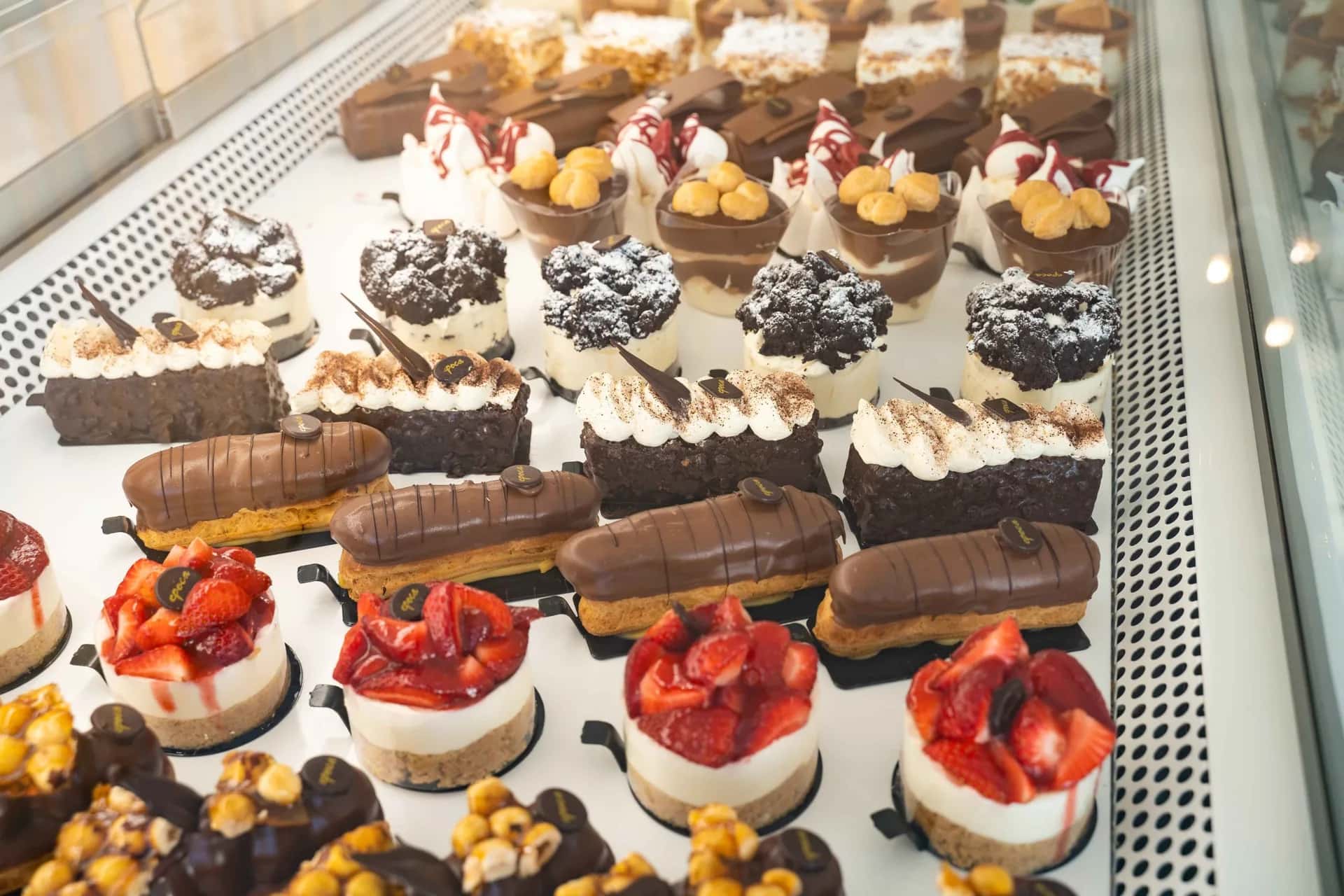 Fresh éclairs, strawberry cheesecakes and chocolate pastries in the patisserie display